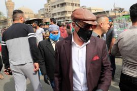 Iraqi men wearing protective masks, following the outbreak of coronavirus, as they walk at the Ghazal pet market in Baghdad, Iraq March 13, 2020. REUTERS/Thaier Al-Sudani