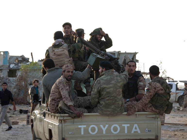 Members of forces loyal to former general Khalifa Haftar ride in a truck in the Benina area, east of Benghazi October 24, 2014. Violent clashes have taken place over the past few weeks between these forces loyal to Haftar and both the Islamist group, the Shura Council of Libyan Revolutionaries, and an alliance of former anti-Gaddafi rebels Ansar al-Sharia, for control of the airport nearby. The two latter groups have now withdrawn and the area is being controlled by these forces loyal to Haftar. Libya's army and its allies have taken control of one of the largest camps of Islamist forces in the eastern city of Benghazi, military officials said on Friday. Picture taken October 24. REUTERS/Stringer (LIBYA - Tags: CIVIL UNREST POLITICS MILITARY)