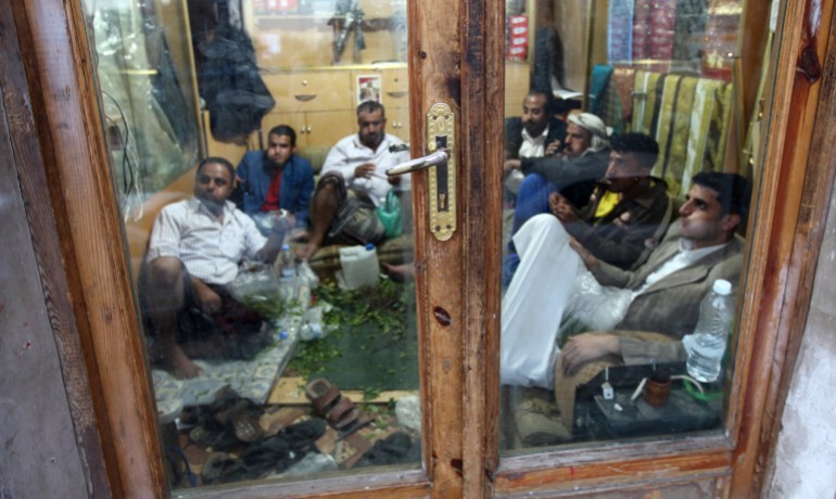 Men chew qat, a mild stimulant, inside a shop in Sanaa's Old City district