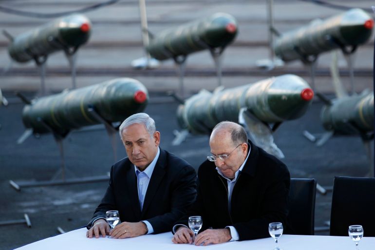 Netanyahu and Yaalon sit in front of a display of M302 rockets at a navy base in Eilat