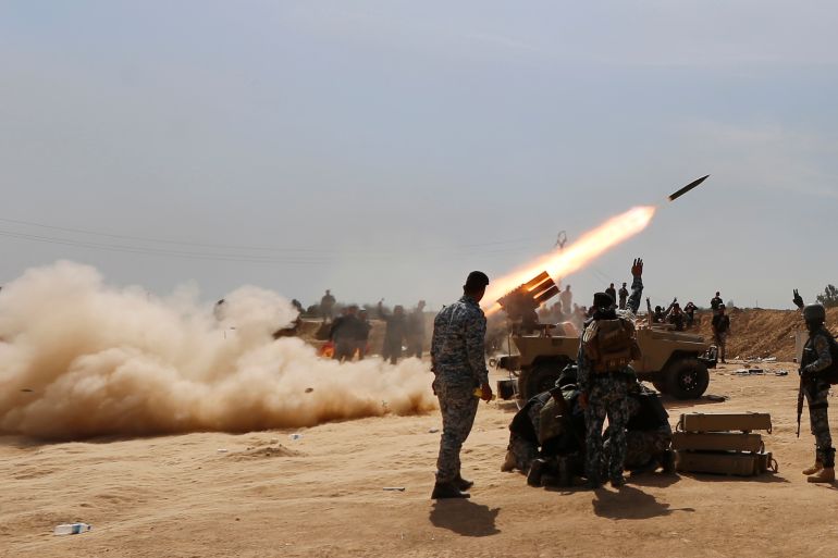 Members of the Iraqi security forces and Shi'ite fighters fire a rocket, during clashes with Islamic State militants in the town of Tal Ksaiba, near the town of al-Alam