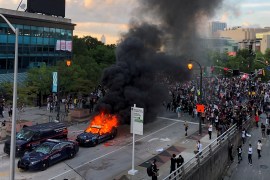 An Atlanta Police car burns as people protest near CNN Center in Atlanta