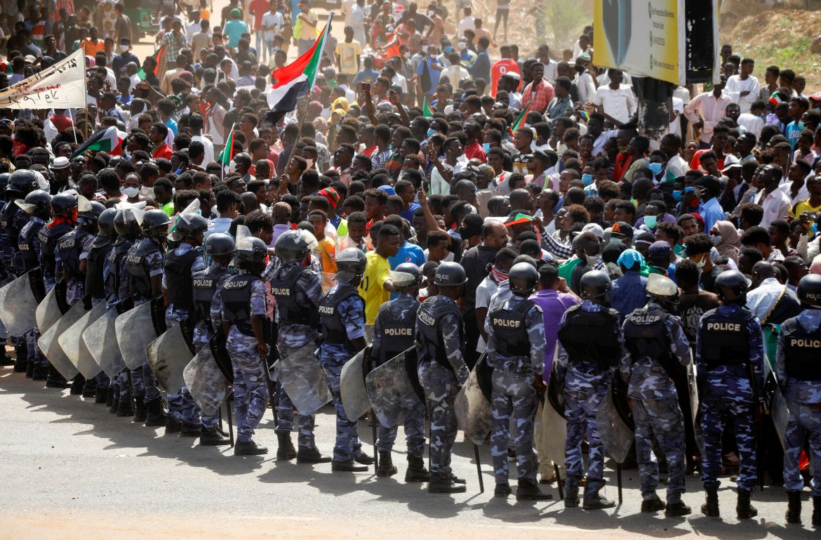 Riot police officers hold position against protesters near the Parliament buildings, in Omdurman, Khartoum