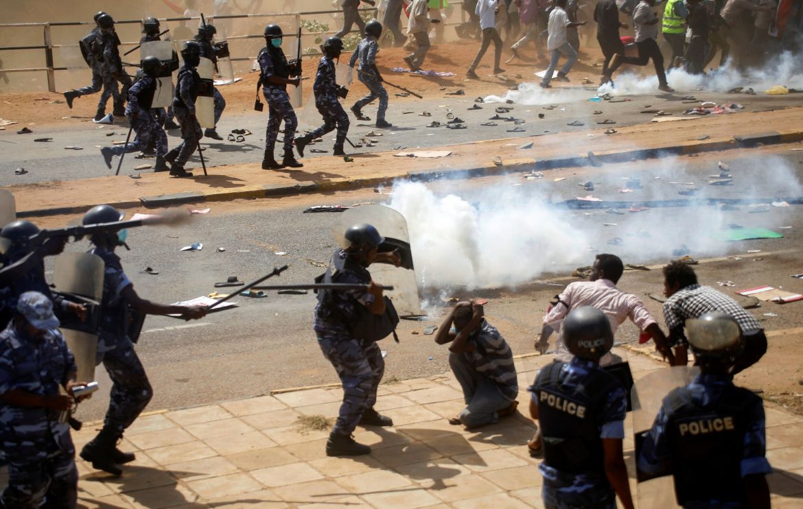 Riot police officers disperse protesters near the Parliament buildings, in Omdurman, Khartoum
