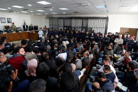 Accused men are seen behind bars during a trial held for over 30 businessmen and customs officials charged with millions of dollars in tax evasion in Amman