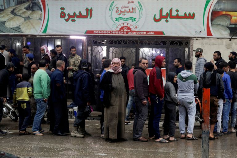 People gather in front of a bakery to buy bread before the time for iftar, or breaking fast, on the first day of the holy month of Ramadan, as the spread of the coronavirus disease (COVID-19) continues, in the rebel-held Idlib city