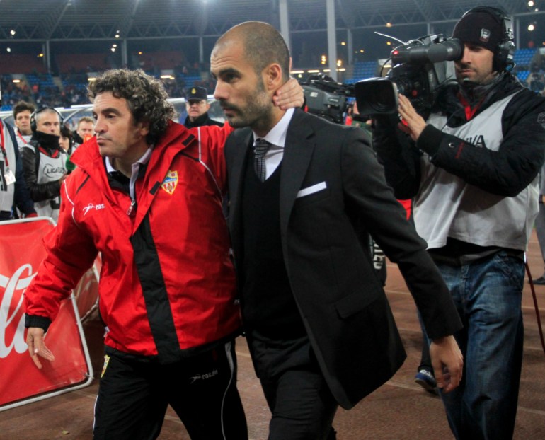 Almeria's coach Lillo and Barcelona's coach Guardiola leave the pitch at the end of their Spanish first division soccer match against Barcelona in Almeria.