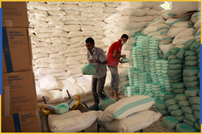 Workers prepare foodstuff for beneficiaries at a food distribution center supported by the World Food Program in Sanaa