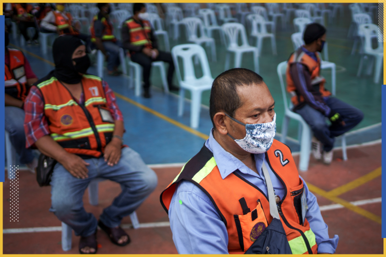 Motorcycle taxi drivers, in protective masks, who are affected by the government's measures against the coronavirus disease (COVID-19) spread, wait for free meals distributed by volunteers at a school in Bangkok, Thailand, May 2, 2020. REUTERS/Athit Perawongmetha