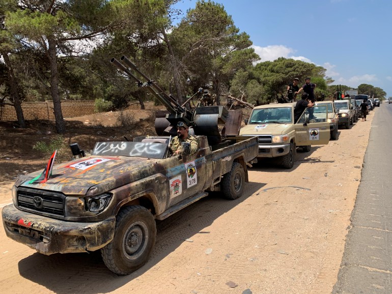 Troops loyal to Libya's internationally recognized government are seen in military vehicles as they prepare before heading to Sirte, in Tripoli