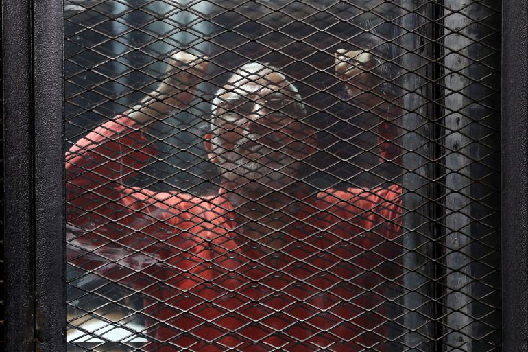 Muslim Brotherhood's leader Mohamed Badie shouts solgans against the Interior Ministery behind bars during the trial of 738 brotherhood members for their armed sit-in at Rabaa square, at a court on the outskirts of Cairo