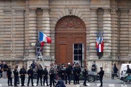 An employee puts the French flag at half mast at the French Senate to pay tribute to the death of former French President Jacques Chirac in Paris