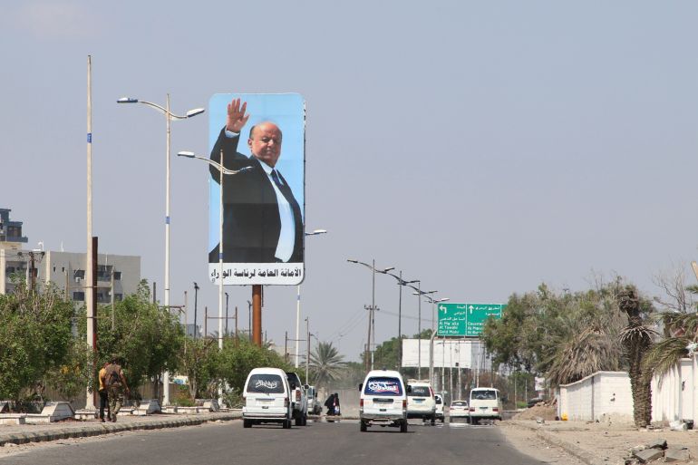 Cars drive past a billboard with a poster of Yemen's President Abd-Rabbu Mansour Hadi in Aden