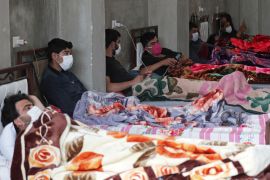 Syrian men lie in beds at a quarantine centre in the town of Jisr al-Shughour