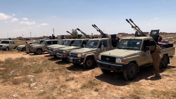 Troops loyal to Libya's internationally recognized government are seen in military vehicles as they prepare before heading to Sirte