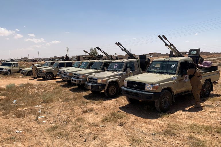 Troops loyal to Libya's internationally recognized government are seen in military vehicles as they prepare before heading to Sirte