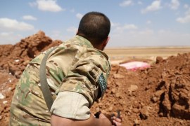 صورة لمقاتل في المعارضة المسلحة يرصد من خلف ساتر ترابي مواقع قوات النزام على اطراف بلدة ميزناز بريف حلب