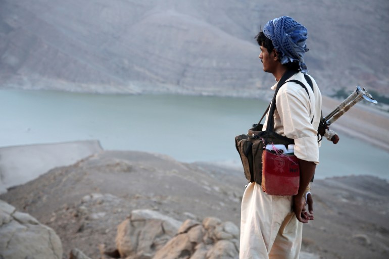 A armed Yemeni tribesmen from the Popular Resistance Committees, supporting forces loyal to Yemen's Saudi-backed fugitive President Abedrabbo Mansour Hadi, stands overlooking the great Dam of Marib, (aka the dam of Arim) in Marib province, east of the capital Sanaa, during ongoing clashes with Shiite Huthi rebels, on September 28, 2015. AFP PHOTO / ABDULLAH HASSAN (Photo by Abdullah Hassan / AFP)