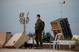 Israeli soldier stands guard next to an Iron Dome anti-missile system near the Israel's northern border with Lebanon