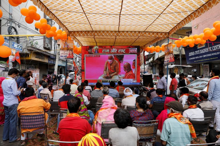 People watch a live screening of the stone laying ceremony of the Ram Temple by Prime Minister Narendra Modi in Ayodhya, in New Delhi
