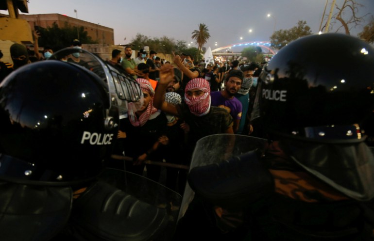 Iraqi demonstrators clash with Iraqi security forces during the ongoing anti-government protests in Basra