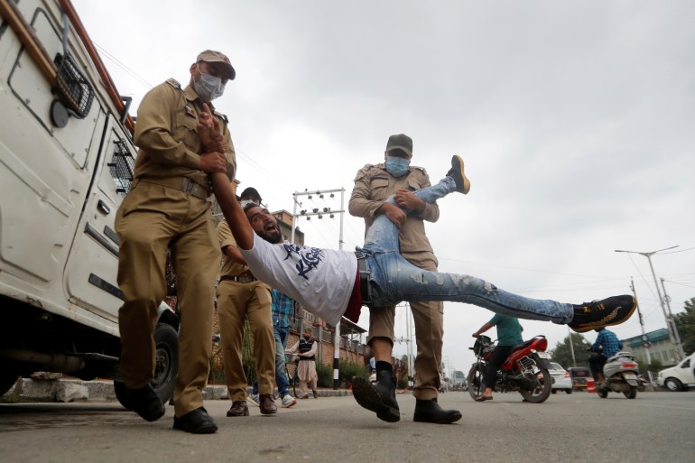A Kashmiri Shi'ite Mulsim reacts as he is detained an Indan policemen while trying to participate in a Muharram procession, in Srinagar