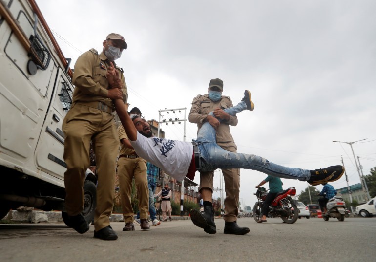 A Kashmiri Shi'ite Mulsim reacts as he is detained an Indan policemen while trying to participate in a Muharram procession, in Srinagar