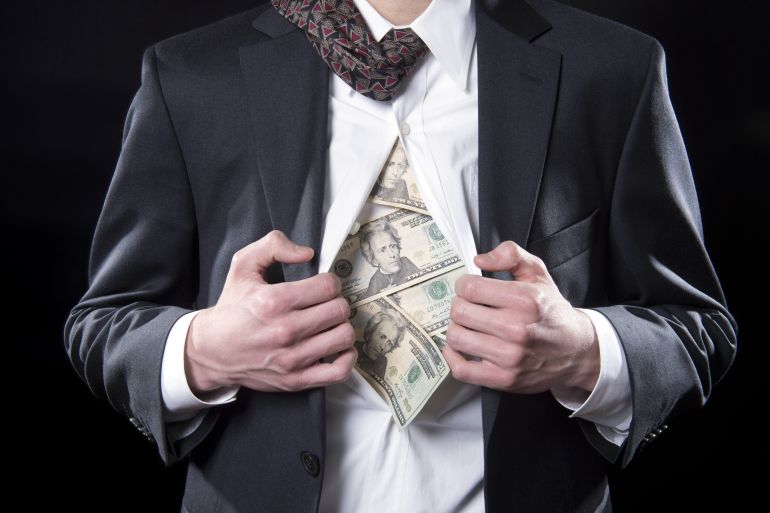 Concept photo for hidden money showing a businessman pulling back his shirt exposing twenty dollar bills; Shutterstock ID 133129163; Department: -