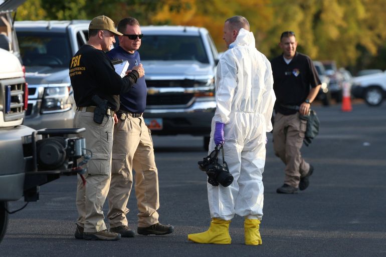 FBI and law enforcement officers put on hazmat suites to prepare to enter a house which FBI says was investigating "potentially hazardous chemicals" in Logan,