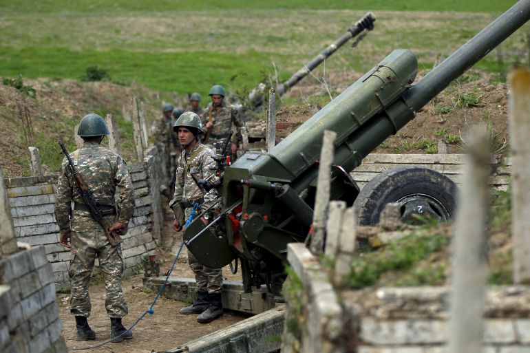 Ethnic Armenian soldiers stand next to a cannon at artillery positions near the Nagorno-Karabakh's town of Martuni