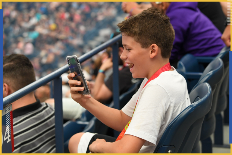 Jul 27, 2019; Flushing, NY, USA; A fan watch the live stream on his phone during the Fortnite World Cup Finals e-sports event at Arthur Ashe Stadium. Mandatory Credit: Dennis Schneidler-USA TODAY Sports