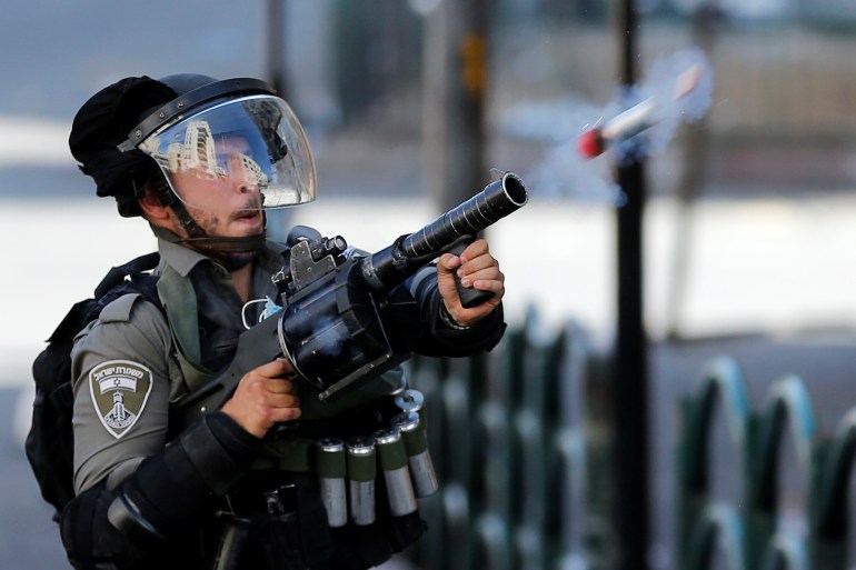 An Israeli border police officer fires a tear gas canister in the Israeli-occupied West Bank