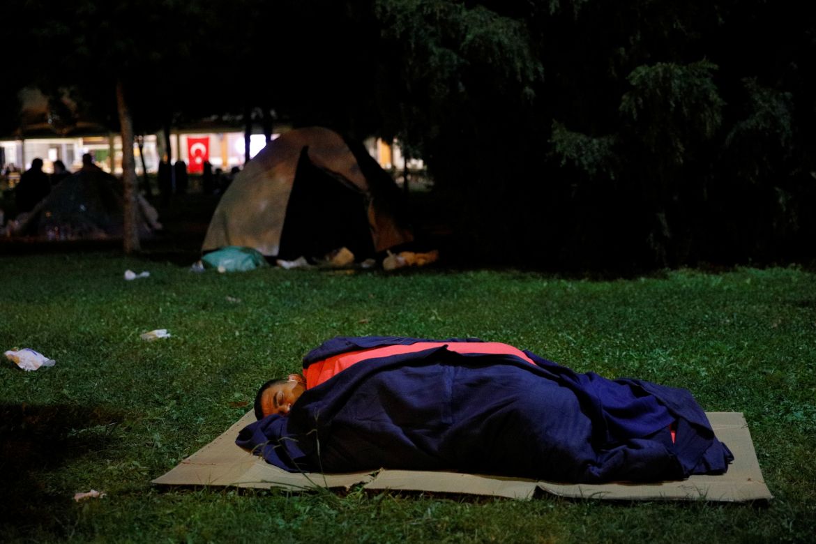 A man affected by an earthquake that struck the Aegean Sea sleeps on the ground, in Izmir