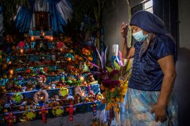 epa08794257 A woman prays in front of her Day of the Dead altar, in Tehuantepec, Mexico, 02 November 2020. Mexico culminated the three-day national mourning decreed by President Andres Manuel Lopez Obrador in honor of the people who died of...