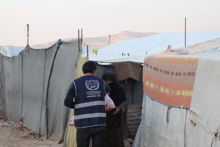 تركيا - إسطنبول- خليل مبروك- متطوع يقدم طردا اغاثيا للاجئة في إحدى المخيمات السورية- الصورة من حساب الهيئة العالمية للإغاثة والتنمية أنصر