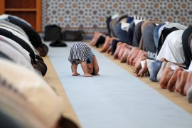 A child is seen near members of the Muslim community attending midday prayers at Strasbourg Grand Mosque in Strasbourg
