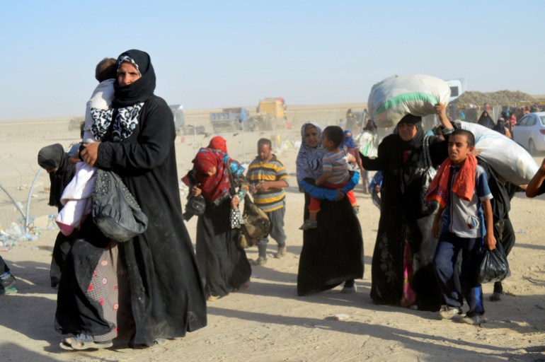 People displaced by violence from Islamic State militants, arrive at a military base in Ramadi