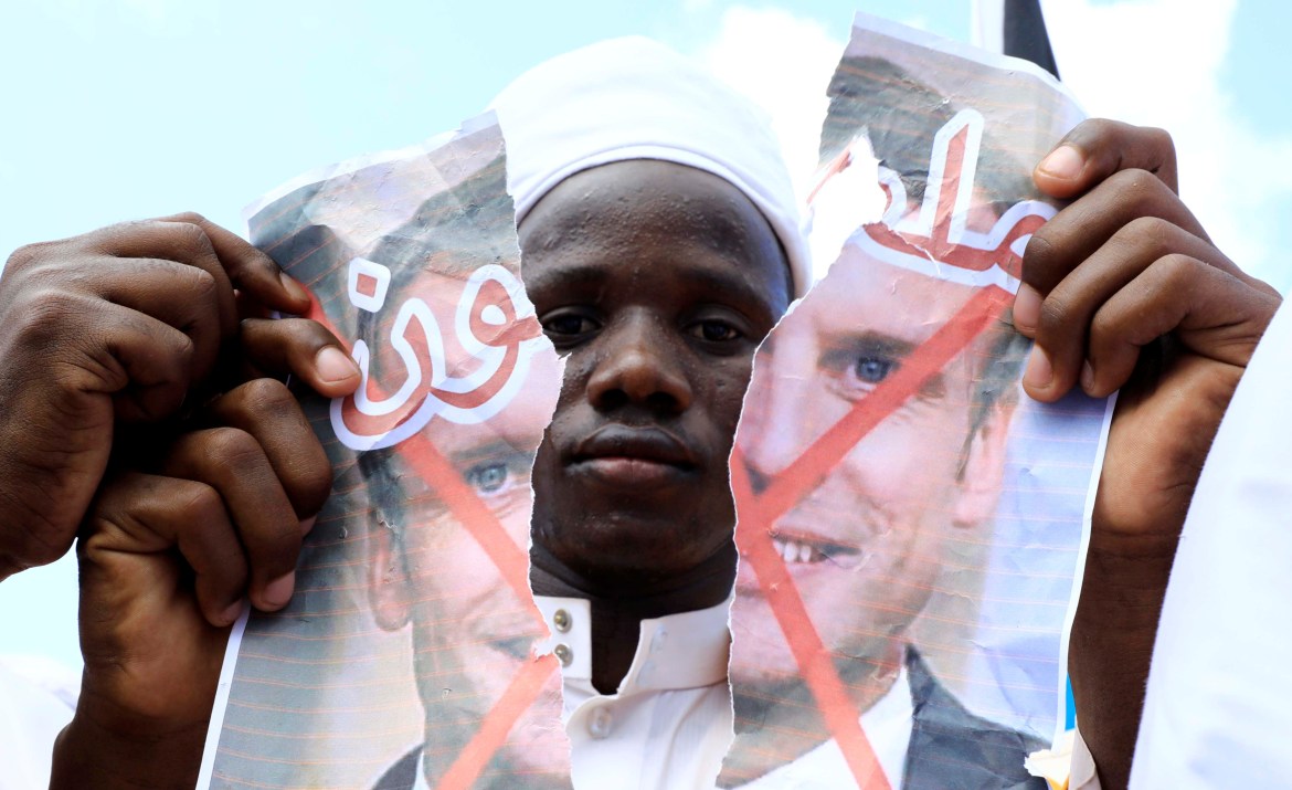 A Somali man tears apart a portrait of French President Emmanuel Macron during a protest against cartoons of Prophet Mohammad published in French media, in Mogadishu