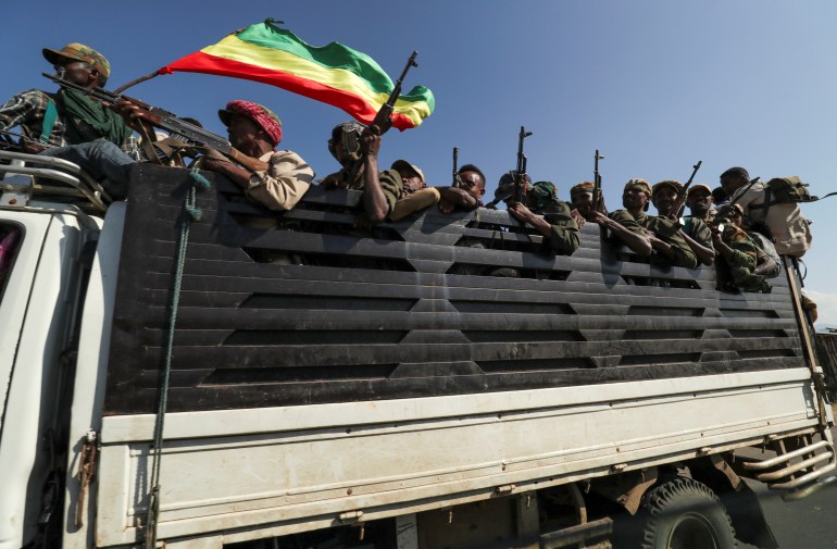 Members of Amhara region militias ride on their truck as they head to face the Tigray People's Liberation Front in Sanja