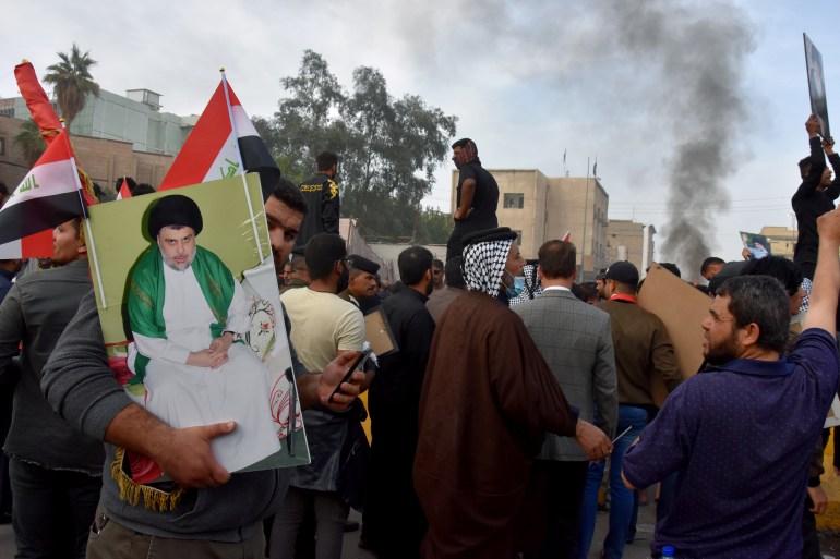 Supporters of Iraqi Shi'ite cleric Moqtada al-Sadr are seen during clashes with anti-government protesters in Nassiriya