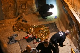 SENSITIVE MATERIAL. THIS IMAGE MAY OFFEND OR DISTURB The body of a person lies on the ground covered as police officers inspect the area after a shooting incident in Jerusalem's Old City, December 21, 2020. REUTERS/Ammar Awad