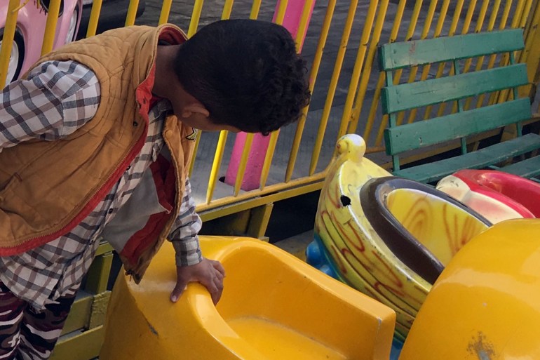 يفحص الفتى العامل لعبته ليجهزها لأقرانه للعب بها. (تصوير خاص لطفل يعمل باحد الملاهي ـ القاهرة ـ ديسمبر 2020)