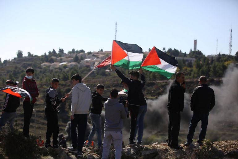 ميرفت صادق فلسطين مدينة البيرة نوفمبر 2020 فتية فلسطينيون يرفعون الأعلام في مواجهات مع قوات الاحتلال قرب مستعمرة بسغوت على جبل الطويل شرق مدينة