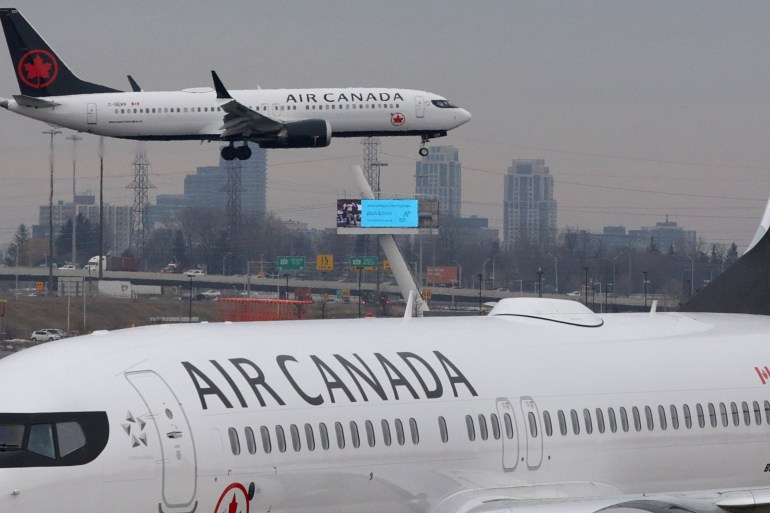 An Air Canada Boeing 737 MAX 8 from San Francisco approaches for landing at Toronto Pearson International Airport over a parked Air Canada Boeing 737 MAX 8 aircraft in Toronto, Ontario, Canada