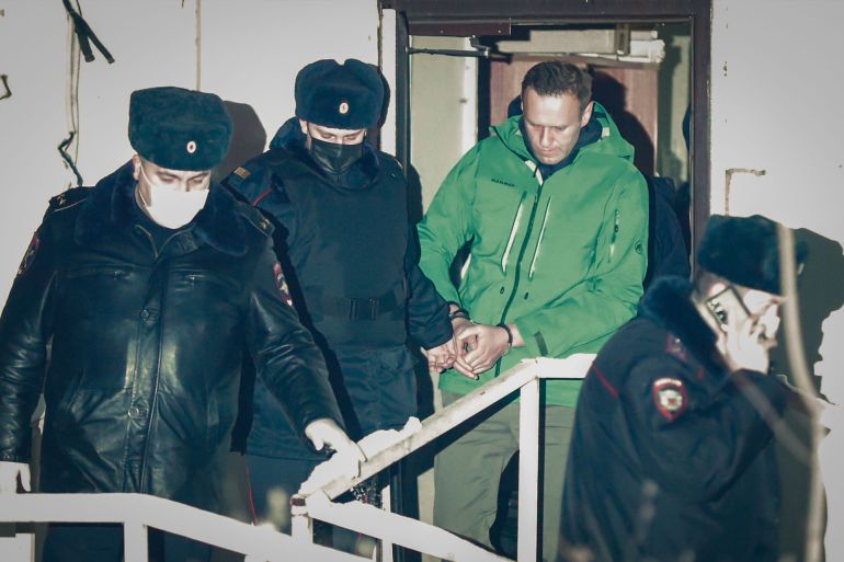 epaselect epa08946489 Russian opposition leader and anti-corruption activist Alexei Navalny (C) is escorted out of a police station in Khimki outside Moscow, Russia 18 January 2021. A Moscow judge on 18 January ruled that Navalny remains in custody...