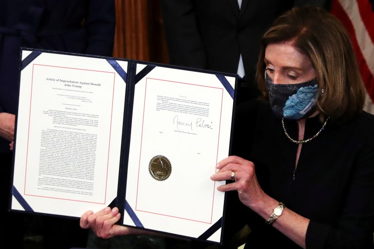 U.S. House Speaker Nancy Pelosi (D-CA) shows the article of impeachment against U.S. President Donald Trump after signing it in an engrossment ceremony, at the U.S. Capitol in Washington January 13, 2021. REUTERS/Leah Millis TPX IMAGES OF THE DAY