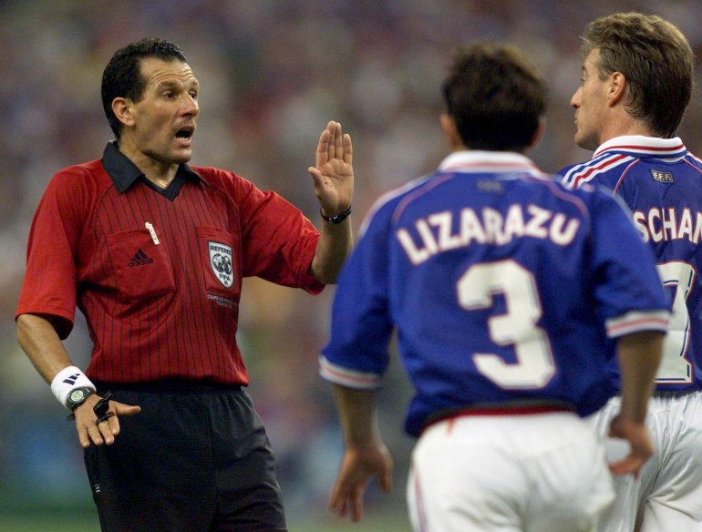 REFEREE SAID BELQOLA RAISES HAND AS FRENCH PLAYERS LIZARAZU AND DESCHAMPS QUESTION CALL ON DESAILLY.