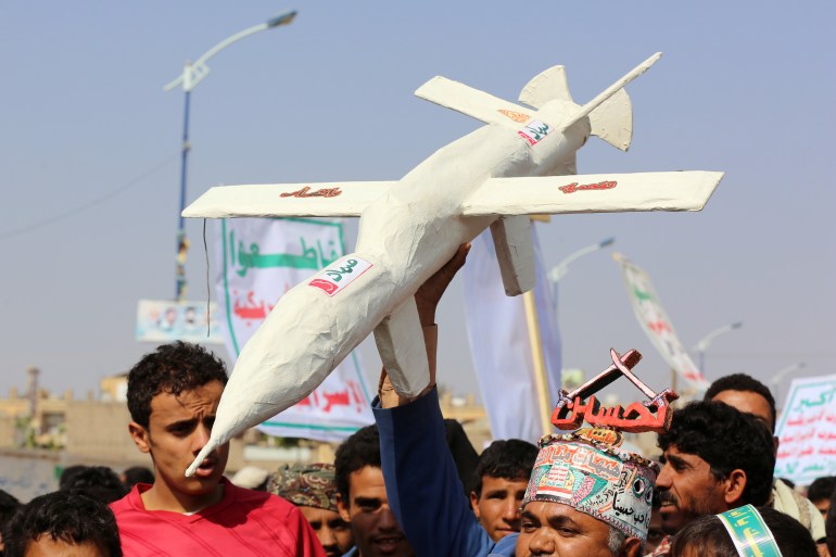 Followers of the Houthi movement carry a mock drone during a rally held to mark the Ashura in Saada