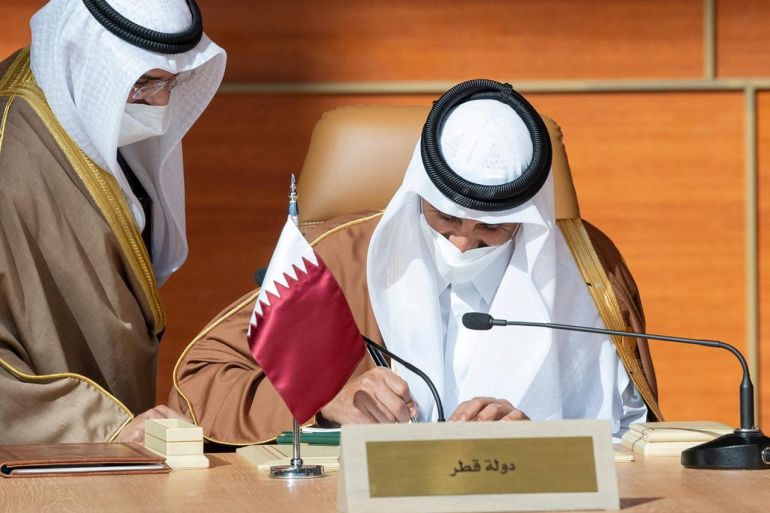 Qatar's Emir Sheikh Tamim bin Hamad al-Thani signs a document during the Gulf Cooperation Council's (GCC) 41st Summit in Al-Ula