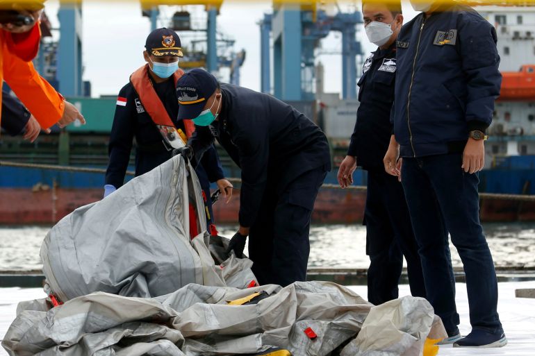 Indonesian rescue members carry what is believed to be the remains of the Sriwijaya Air plane flight SJ182 which crashed into the sea, at Jakarta International Container Terminal port in Jakarta